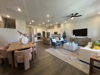 An elegant open-concept living area with a cozy dining space, modern kitchen, and chic furnishings.