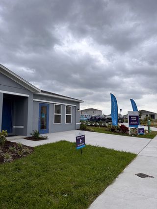 A modern grey model home with a neat yard in The Reserve at Bradbury Creek by Century Complete, Haines City, FL.