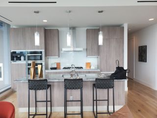Model Home A modern kitchen with sleek cabinetry, a marble island, and chic pendant lighting.