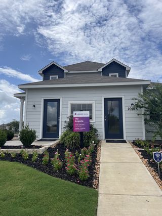 Street view Charming two-story white home with blue accents and vibrant landscaping in Cinco Lakes by Legend Homes, San Antonio, TX.