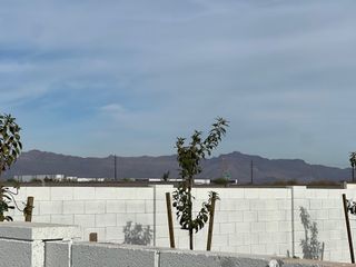 A scenic view of distant mountains beyond a white brick wall in The Estates at North Creek by New Home Co. (Queen Creek, AZ).