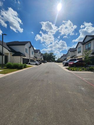 Street view Modern townhomes with sleek designs and manicured lawns in Townhomes at Gattis by Green Abode Developers (Round Rock, TX).