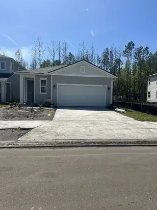 Model Home A modern gray home with a spacious driveway in Seasons at Marietta Cove by Richmond American Homes (Jacksonville, FL).