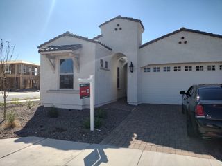 A charming white stucco home with a tiled roof in Aloravita South Summit Collection by Taylor Morrison (Peoria, AZ).