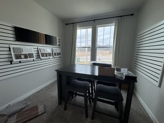 A modern design studio with sample boards, a sleek table, and tall windows providing ample natural light.