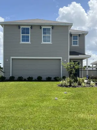 A modern two-story home with a spacious lawn in Avalon Woods by D.R. Horton (Newberry, FL).