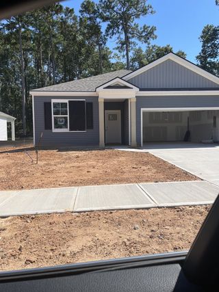 Street view A modern single-story home with navy siding in Settlement at Salamander by D.R. Horton, North Charleston, SC.