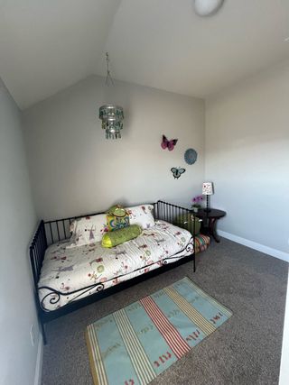 A cozy bedroom with a whimsical daybed, colorful textiles, and butterfly wall decor.