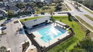Community Amenities A scenic view of the community pool with a beautiful landscape in Parkside On The River by Highland Homes (Georgetown, TX).
