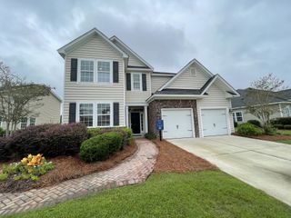 A charming home with a landscaped yard in Lindera Preserve at Cane Bay Plantation: Arbor Collection by Lennar (Summerville, SC).