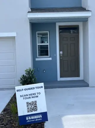 A modern entry at Chelsea Court by D.R. Horton in Tampa, FL, featuring blue accents and inviting landscaping.