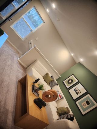 A cozy living space with a white sectional sofa, wooden coffee table, and modern artwork on a green accent wall.