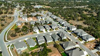 Street view Aerial view of a charming neighborhood featuring spacious homes and manicured lawns at Retreat at San Gabriel by Brightland Homes.