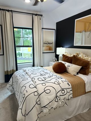 A cozy bedroom with modern art, stylish bedding, and natural light, creating a serene and inviting atmosphere.