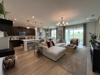 A spacious open-concept living area featuring a modern kitchen, cozy seating, and elegant lighting, perfect for entertaining.