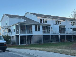 Charming white multi-story home with spacious porches in Liberty Hill Farm by K. Hovnanian® Homes (Mount Pleasant, SC).