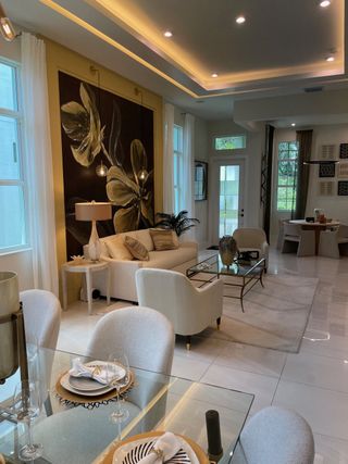 A sophisticated living and dining area with elegant lighting, plush seating, and a glass dining table for a modern touch.
