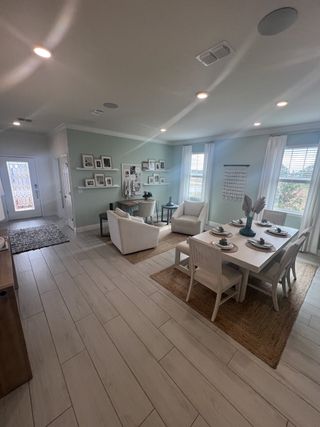Model Home An elegant living-dining area with sleek flooring, soft lighting and tasteful decor, creating a cozy atmosphere.