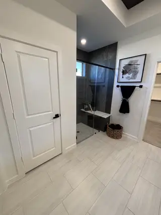 A modern bathroom with sleek gray tiles, a walk-in shower, and minimalist decor for a stylish, contemporary feel.