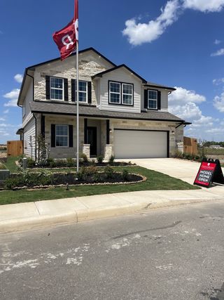 A modern two-story home with elegant stone accents and a manicured lawn in Hennersby Hollow by CastleRock Communities (San Antonio, TX).
