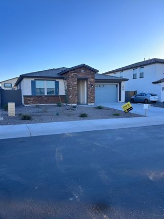 A modern home with stone accents and a landscaped front yard in Cordillera by KB Home (Gilbert, AZ).