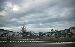 Charming neighborhood with scenic pond and modern homes in Hawthorn Park at Wildlight by Pulte Homes (Wildlight, FL).