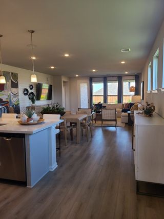 A modern living area with sleek hardwood floors, pendant lighting, and large windows offering abundant natural light.