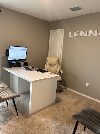 Model Home A modern office space with a sleek white desk and comfortable seating.