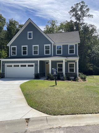 A charming gray clapboard home with a manicured lawn in Summerville Single Family Homes by Ryan Homes (Summerville, SC).