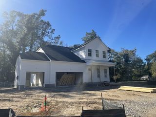 Street view A modern white home under construction in Fiddler Cove by DRB Homes, located in scenic Mount Pleasant, SC.