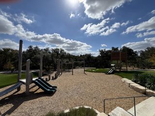 A charming playground with wooden structures under a bright sky in Wolf Ranch by Pulte Homes (Georgetown, TX).