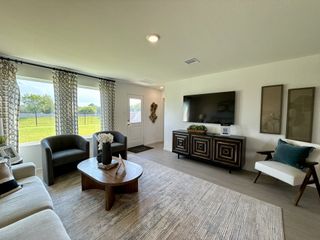 A cozy living room with patterned curtains, sleek furniture, a modern TV setup, and a view of the spacious backyard.