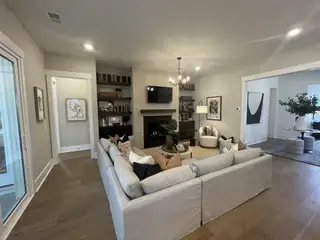 A cozy living room with a sectional sofa, elegant built-ins, a fireplace, and chic art, offering modern comfort and style.