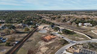 Aerial view of a developing neighborhood in Broken Oak by Highland Homes, showcasing spacious lots and natural surroundings (Georgetown, TX).