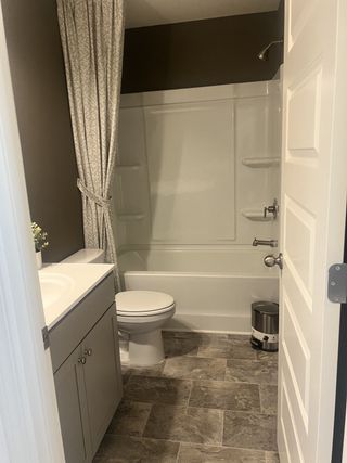 A cozy bathroom featuring a sleek vanity, patterned shower curtain, and tiled flooring for a refined touch.