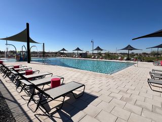Community Amenities Chic outdoor pool area with loungers and shade structures in Silva Farms by Meritage Homes (Goodyear, AZ).
