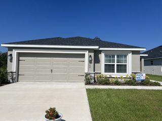 Street view A charming home with a sleek garage and manicured lawn in Stonebridge North by Highland Homes of Florida (Zephyrhills, FL).