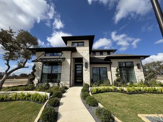 A modern stone home with pristine landscaping in Parmer Ranch 50' by Perry Homes (Georgetown, TX).