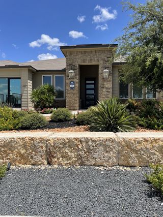 A charming brick home with lush landscaping in Riverstone at Westpointe by D.R. Horton (San Antonio, TX).
