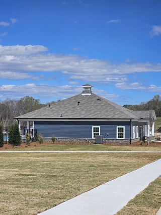 A modern blue clubhouse with stone accents in Preserve at Mountain Creek by Meritage Homes (Pendergrass, GA).