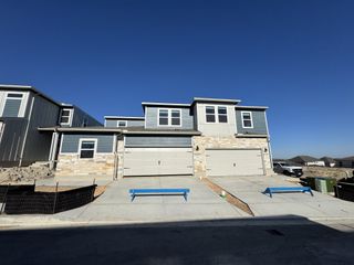 A modern duplex with stone accents and spacious driveways in Turner's Village by Meritage Homes (Buda, TX).