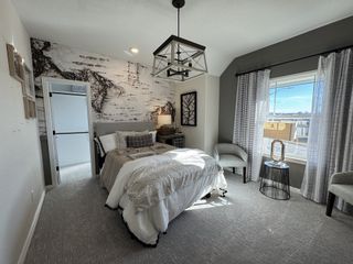 A stylish bedroom featuring a striking wood-grain wallpaper accent wall, where the neutral color palette, cozy bedding, and natural light create a calm retreat.