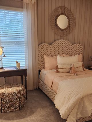 Model Home A charming bedroom with a floral-patterned bed, soft neutral hues, and a delicate mirror, creating a dreamy and elegant retreat.