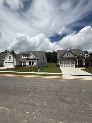 Street view A charming suburban street with modern homes and manicured lawns in Twelve Parks 55+ by Lennar (Sharpsburg, GA).