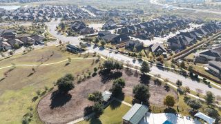 A scenic aerial view of Sunfield by CastleRock Communities, showcasing winding paths and well-planned homes in Buda, TX.