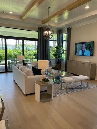 A modern living room with wood beams, large windows, and sleek furnishings, creating a cozy and elegant space.
