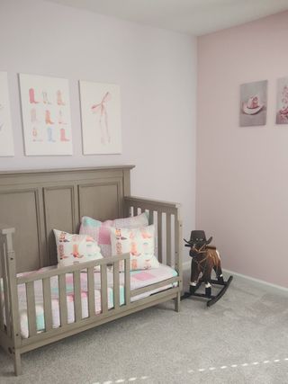 A charming toddler’s bedroom with soft pastel walls, Western-themed décor, and cozy bedding in Copes Landing by D.R. Horton (Jacksonville, FL).