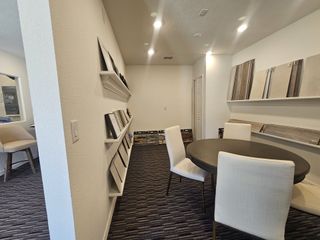 A modern interior with sample displays, a round table, and elegant seating, ideal for creative planning and design discussions.