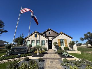 Street view A beautifully designed Highland Homes residence in La Cima, San Marcos, TX, with elegant stone accents and meticulous landscaping.