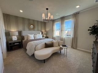 Model Home A cozy bedroom with a stylish accent wall, elegant lighting, and a plush bed, creating a serene retreat atmosphere.